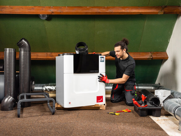 Installer with Comfo Air Q, attic, craftsman, tools, comfo pipe