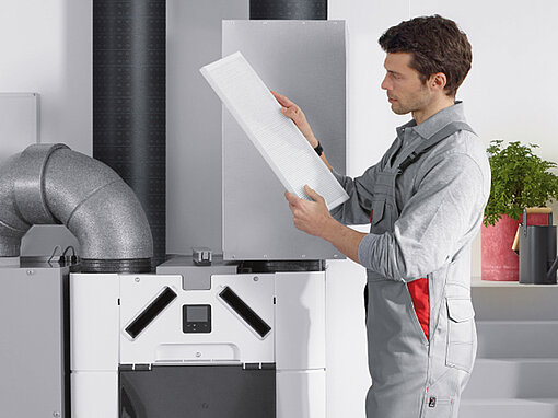 [Translate to Deutsch:] Zehnder filter wechseln mann mit filter